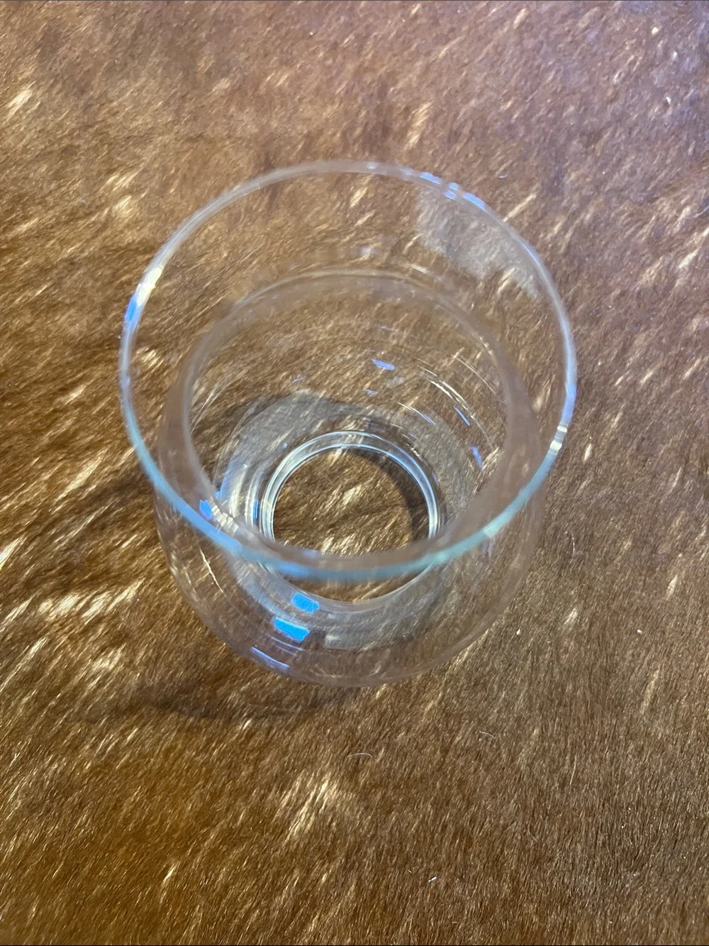 Clear glass hurricane candle holder features a pedestal base and a flared top